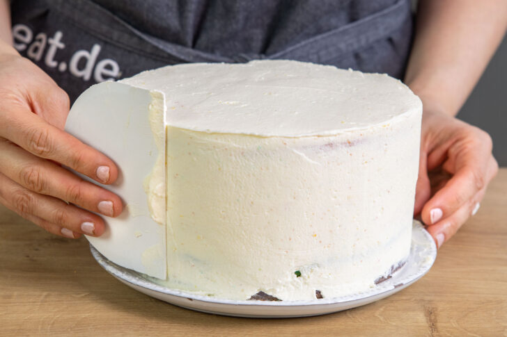 Regenbogenkuchen mit Creme einstreichen