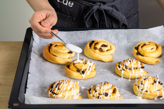 Rosinenschnecken mit Zuckerguss verzieren