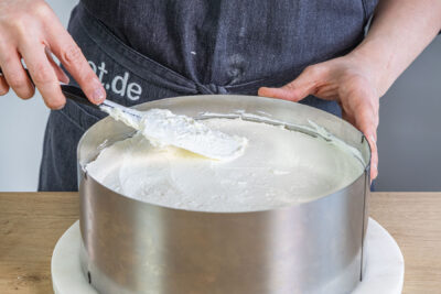 Creme auf dem Rotkäppchenkuchen verstreichen