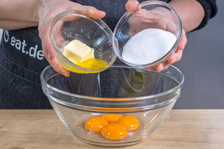 Zucker und Butter zu den Eiern geben