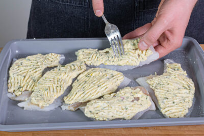 Masse für die Kruste auf den Fischfilets verteilen