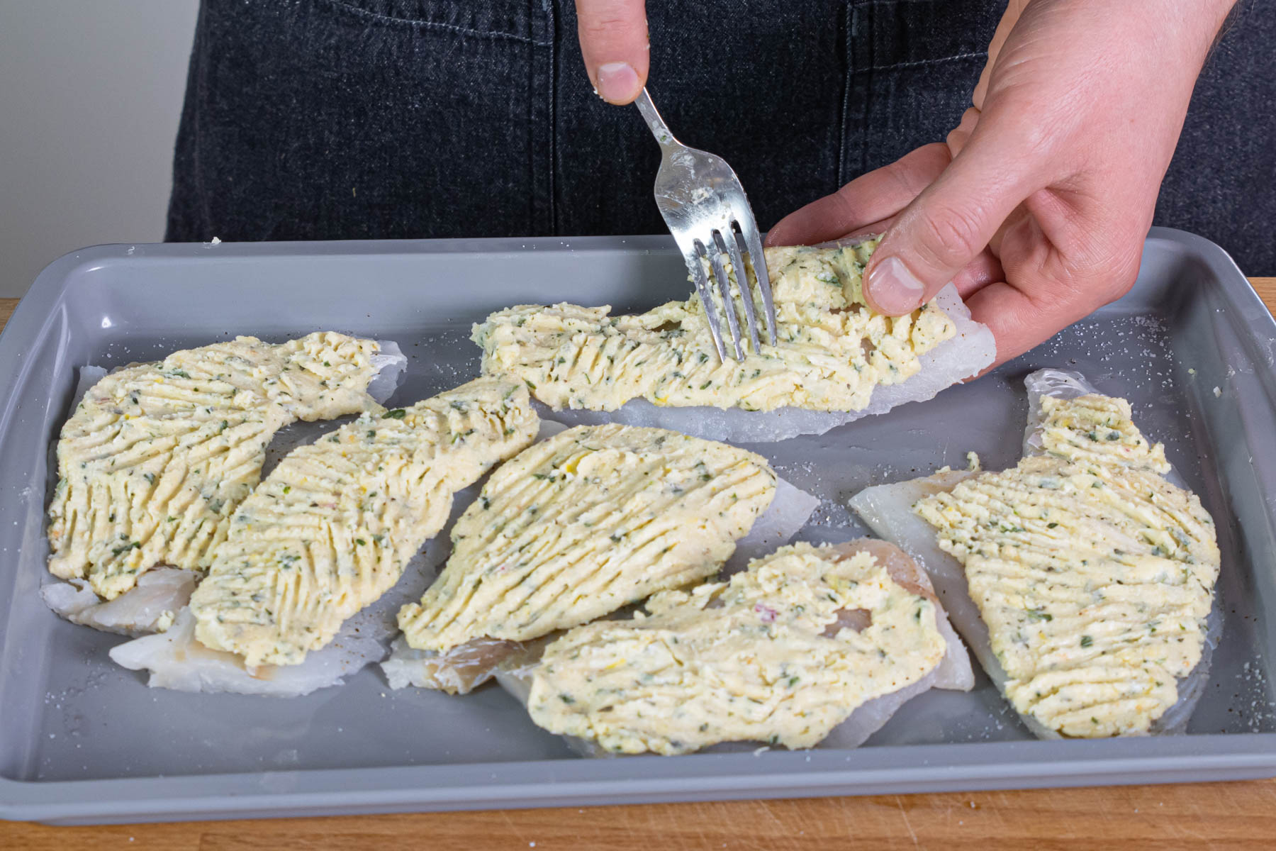 Masse für die Kruste auf den Fischfilets verteilen