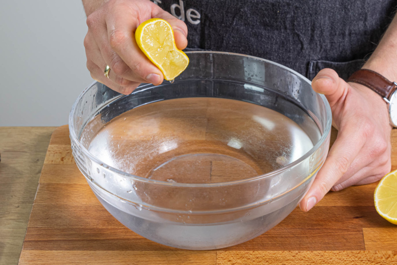 Zitronensaft in kaltes Wasser pressen