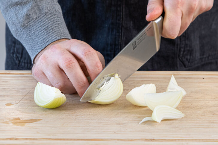 Zwiebel in mundgerechte Stücke schneiden