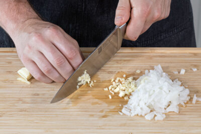 Knoblauch und Zwiebeln in Würfel schneiden