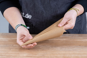 Backpapier zu einem Spritzbeutel rollen