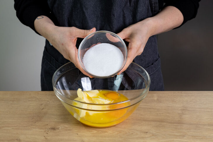 Zucker zu Butter und Eigelb geben