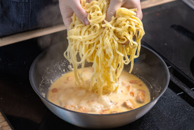 Tagliatelle zum Lachs in Sahne-Sauce geben