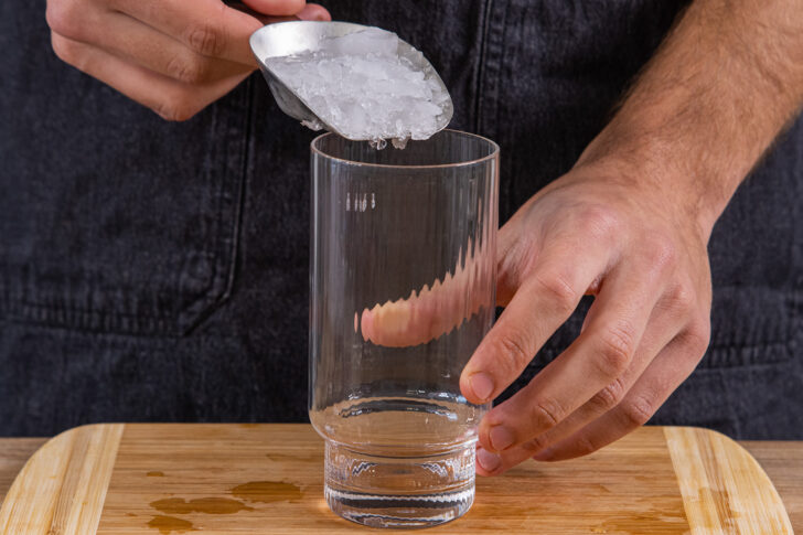 Eis in ein Glas geben
