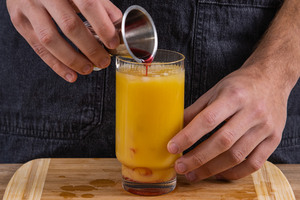 Grenadine in das Glas geben