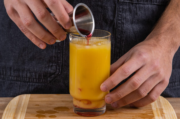Grenadine in das Glas geben