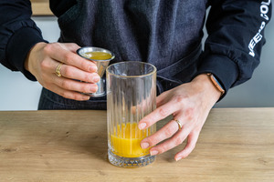 Ananassaft ins Glas gießen