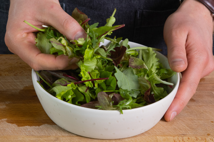 Salat in eine Schüssel geben