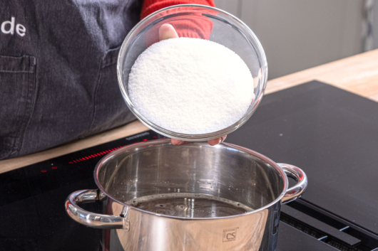 Zucker zum Apfelsaft geben