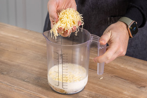 Käse zu der Ei-Sahn-Mischung geben