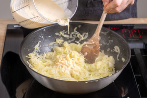 Ei-Sahne-Käse-Mischung zu den Zwiebel geben