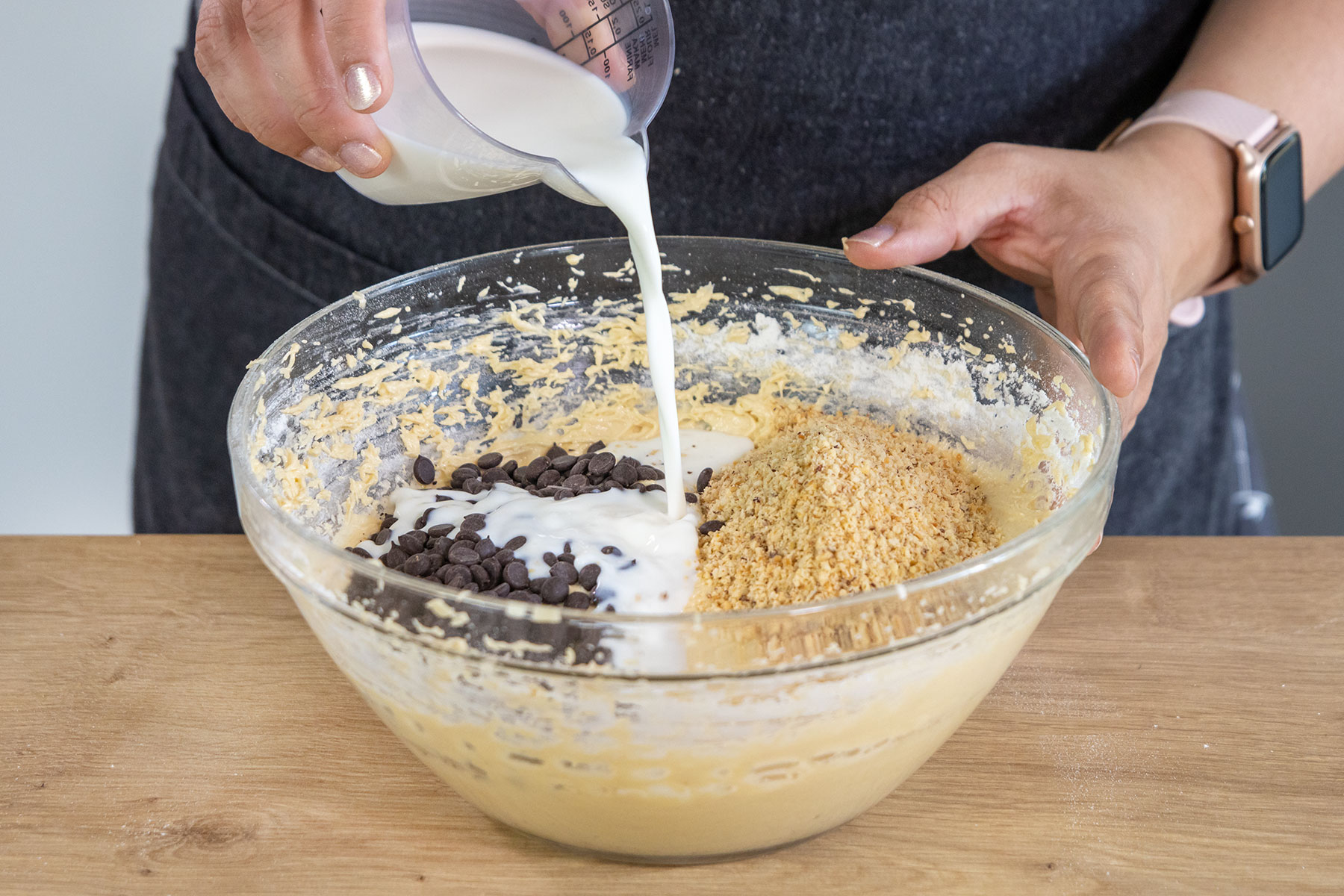 Milch zum Teig für den Kirschkuchen gießen