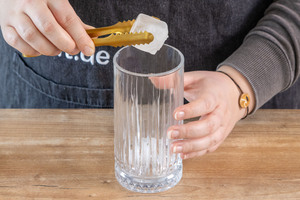 Eiswürfel ins Glas geben