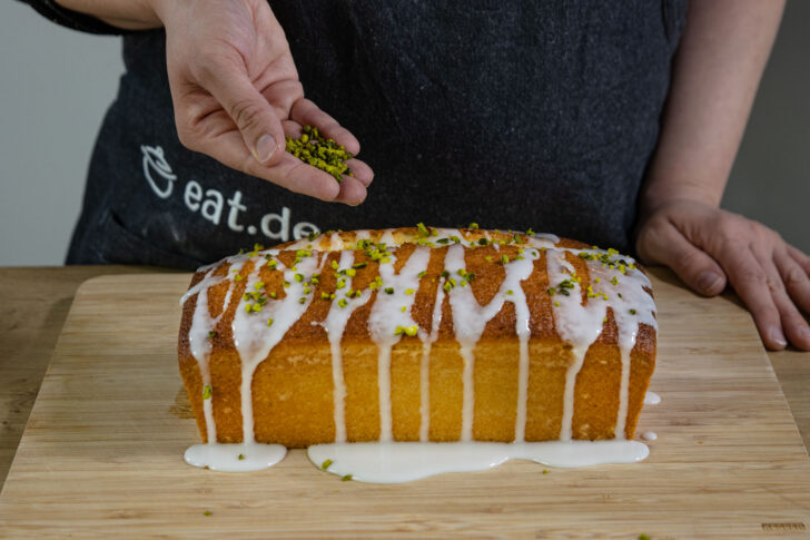 saftigen Zitronenkuchen mit Pistazien dekorieren