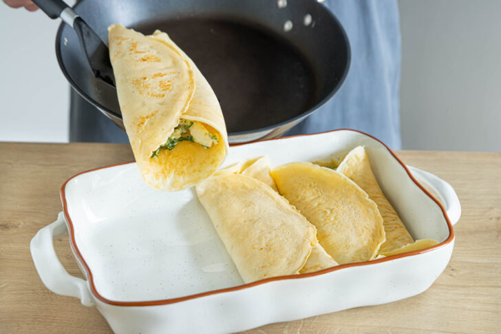 Pfannkuchen mit Spinat in die Auflaufform geben