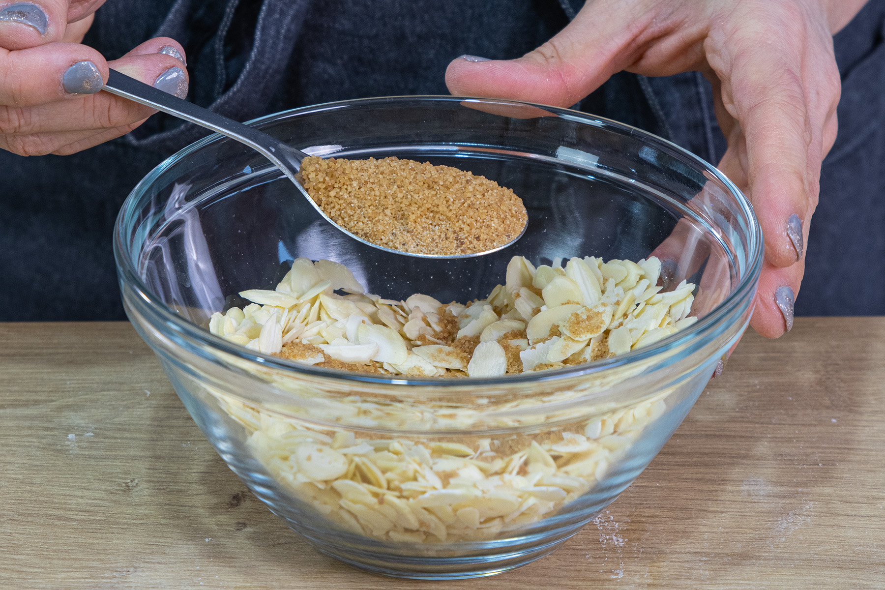Braunen Zucker über die Mandelblättchen geben