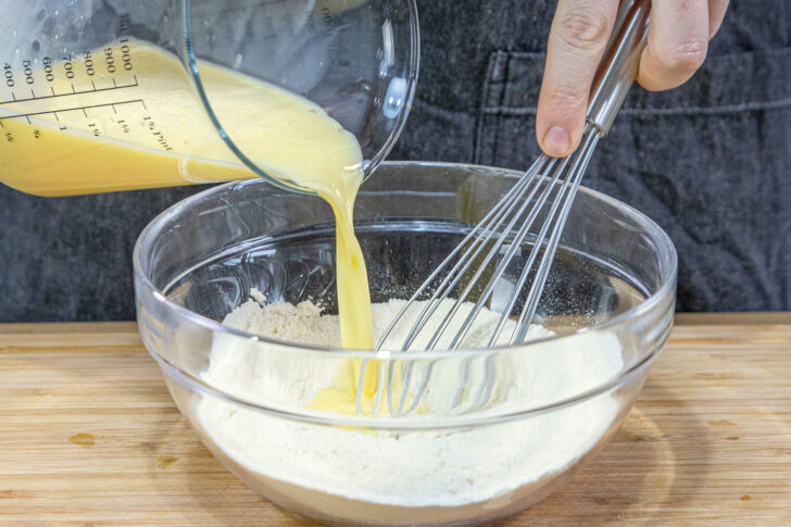 Eier-Milch-Mischung zum Mehl gießen