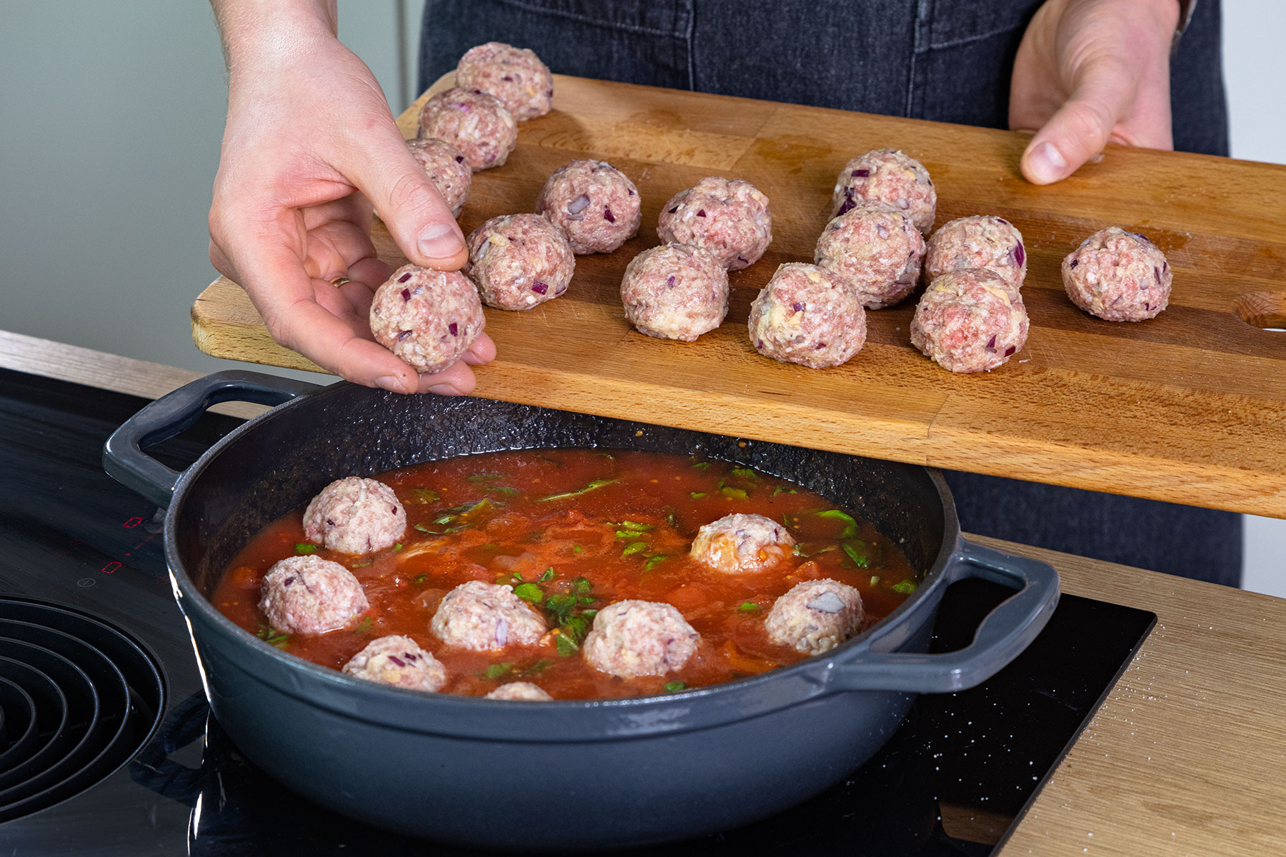 Hackbällchen in die Sauce legen