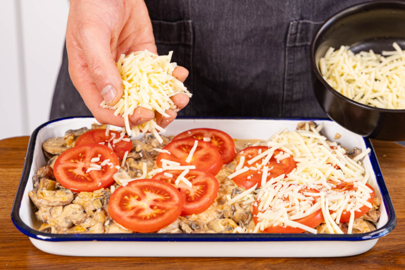 Tomaten auf die Schnitzel geben und mit Käse bestreuen