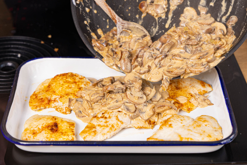 Soße auf den Schnitzeln verteilen