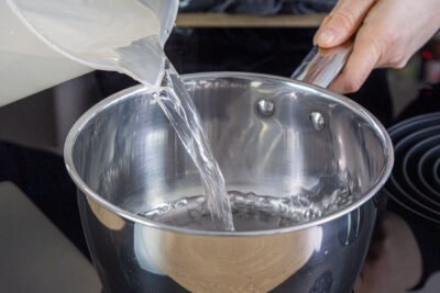 Wasser in den Topf gießen
