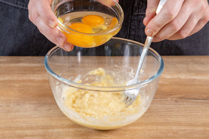 Eier zu der zerdrückten Banane geben