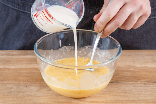 Milch in die Schüssel gießen