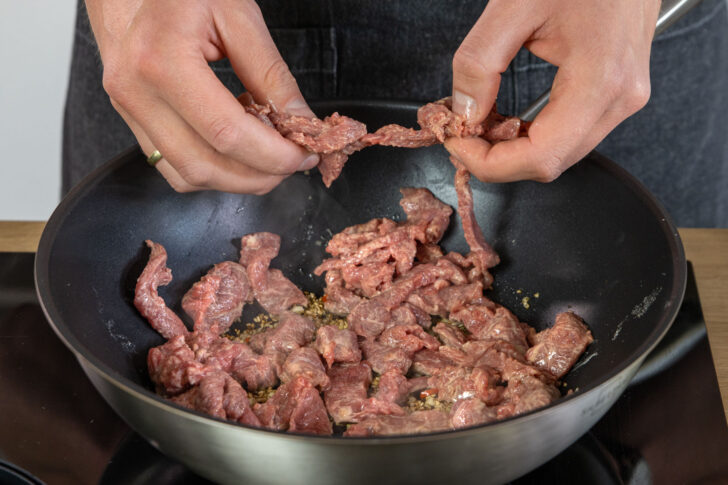 Rindfleisch in Pfanne geben