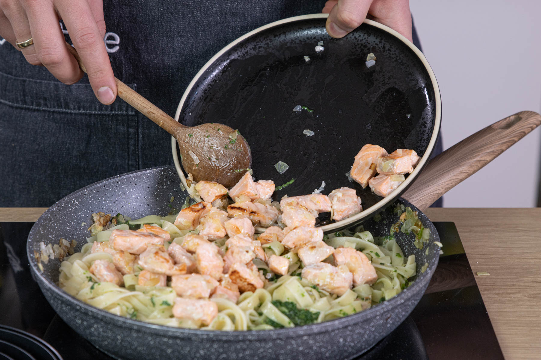 Lachs zu den Tagliatelle mit Spinat-Sahne-Sauce geben