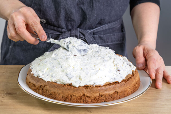 Sahne auf den Kuchen geben