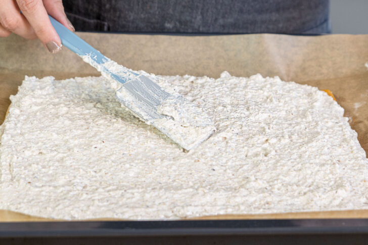 Teig für Mini-Nussecken mit Eischnee backen verteilen