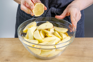Zitronensaft über die Apfelspalten geben