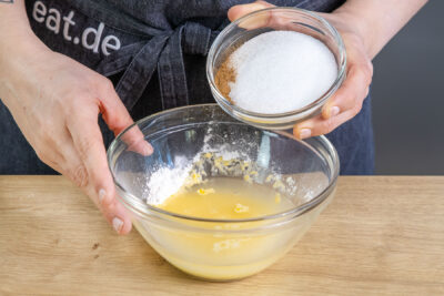 Puddingpulver, Zucker und Zimt zu dem Weißwein geben