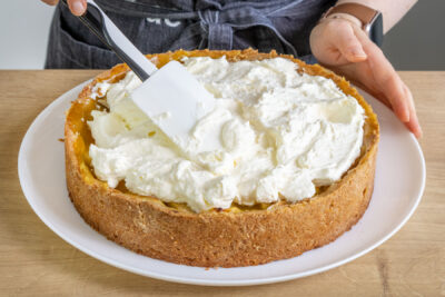 Sahnehaube auf den Apfelweinkuchen auftragen