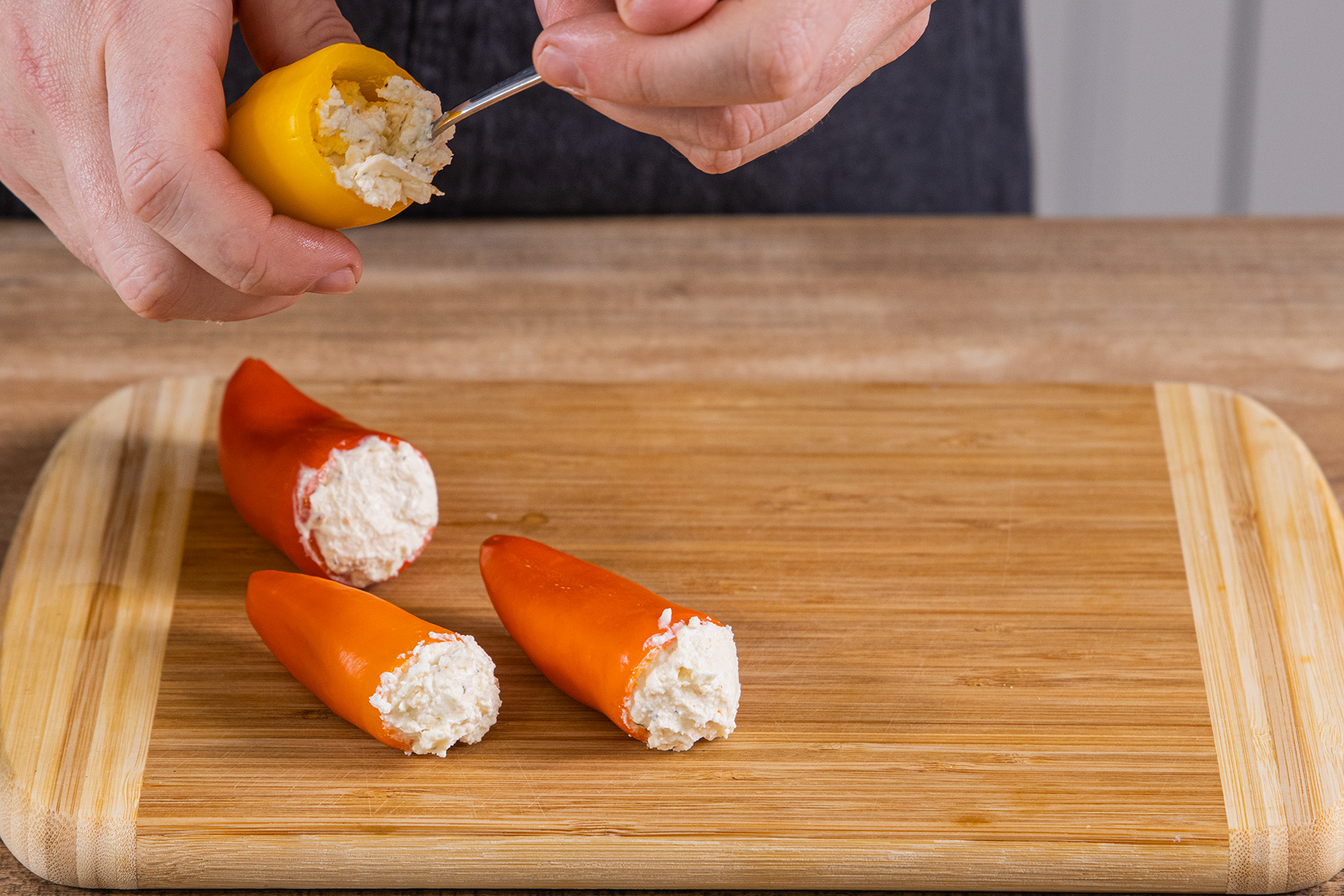 Feta-Frischkäse-Mischung in die Spitzpaprikas füllen