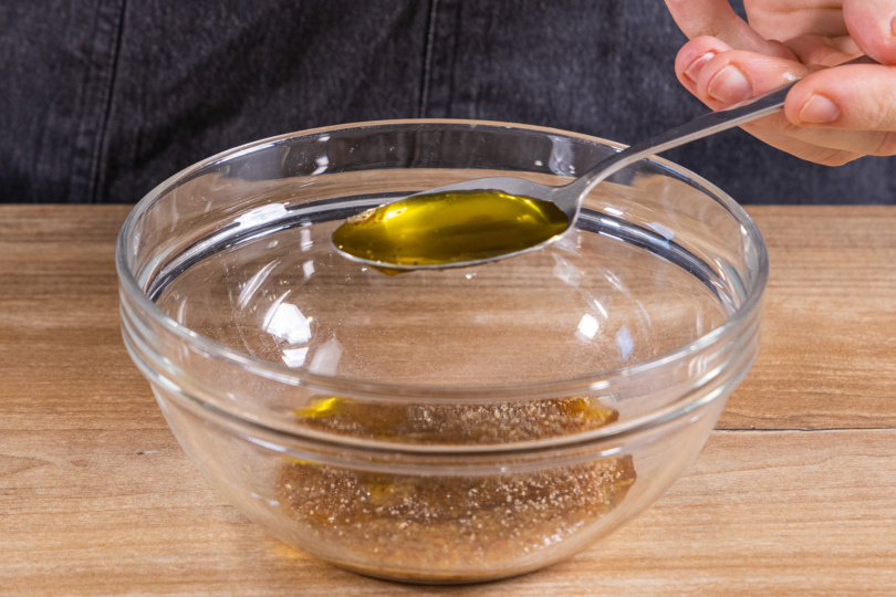 Olivenöl zum Honig und süßen Senf in die Schüssel geben