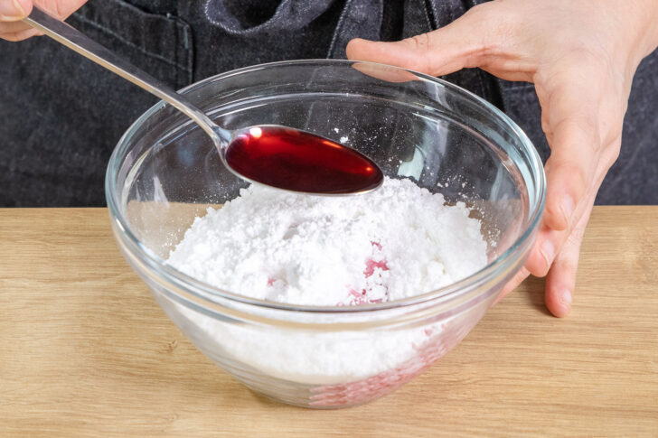 Kirschsaft zu dem Puderzucker geben