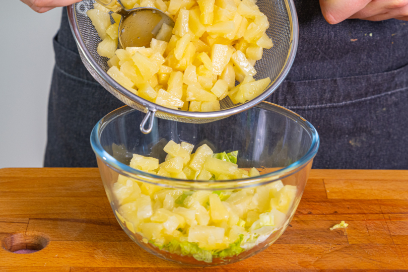 Ananas über Eisbergsalat geben