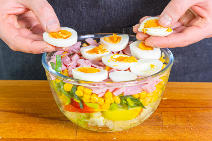 Eier auf den Schichtsalat legen