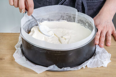 Creme auf dem Boden der Erdbeertorte verteilen