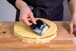 Pudding auf dem zweiten Mandeltorten Boden verstreichen