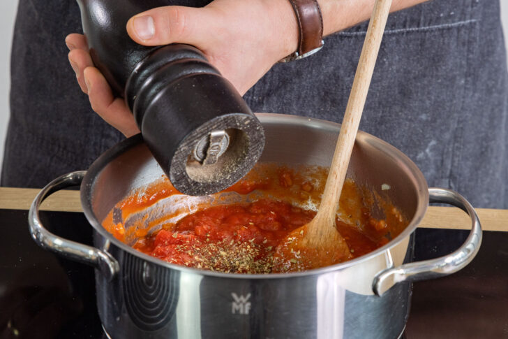 Tomatensoße mit Pfeffer würzen
