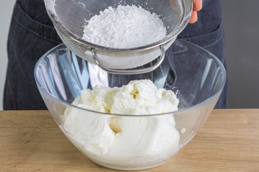 Puderzucker mit griechischem Joghurt und Magerquark vermischen