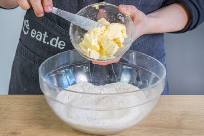 Butter zu Mehl und Zucker geben