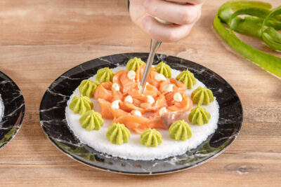 Wasabi-Mayonnaise auf die Sushi-Pizza spritzen